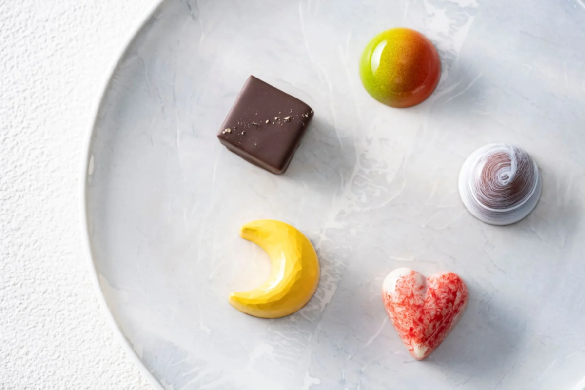 白いプレートに、様々な形と色の高級感あふれるボンボンショコラが5つ並べられています