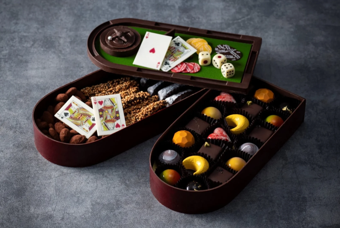 カジノゲームをテーマにした、トランプやサイコロの形をしたチョコレートと、様々な種類のプラリネが詰め合わせられた豪華なアソートメント