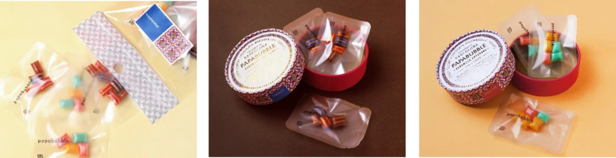 パパブブレのカラフルな手作りキャンディが個包装されており、一部は赤い丸いギフトボックスに詰められています